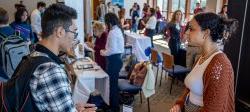 Picture of an prospective employer and student talking at a career fair.