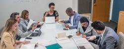 Picture of students working together around a classroom table.